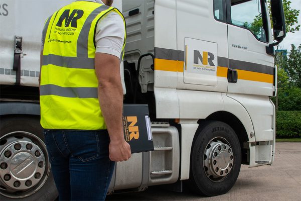 Man with NRI Clipboard and Hi-Vis approaching truck